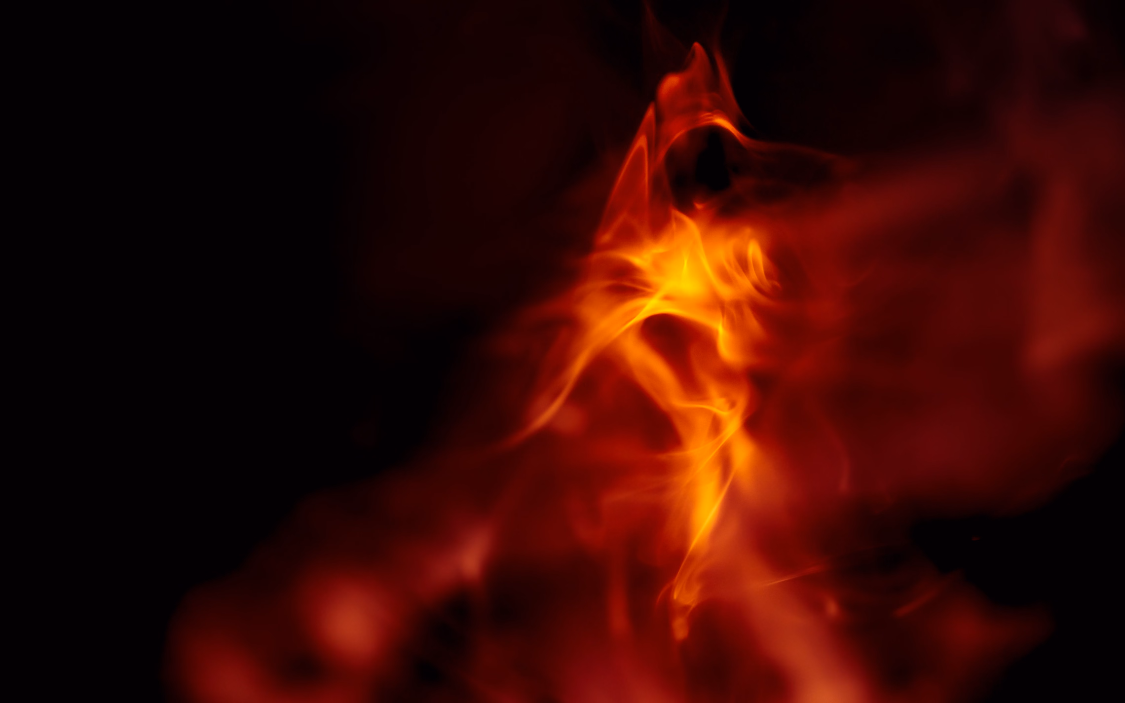 Wisps of orange and red flame curling upward against a black background