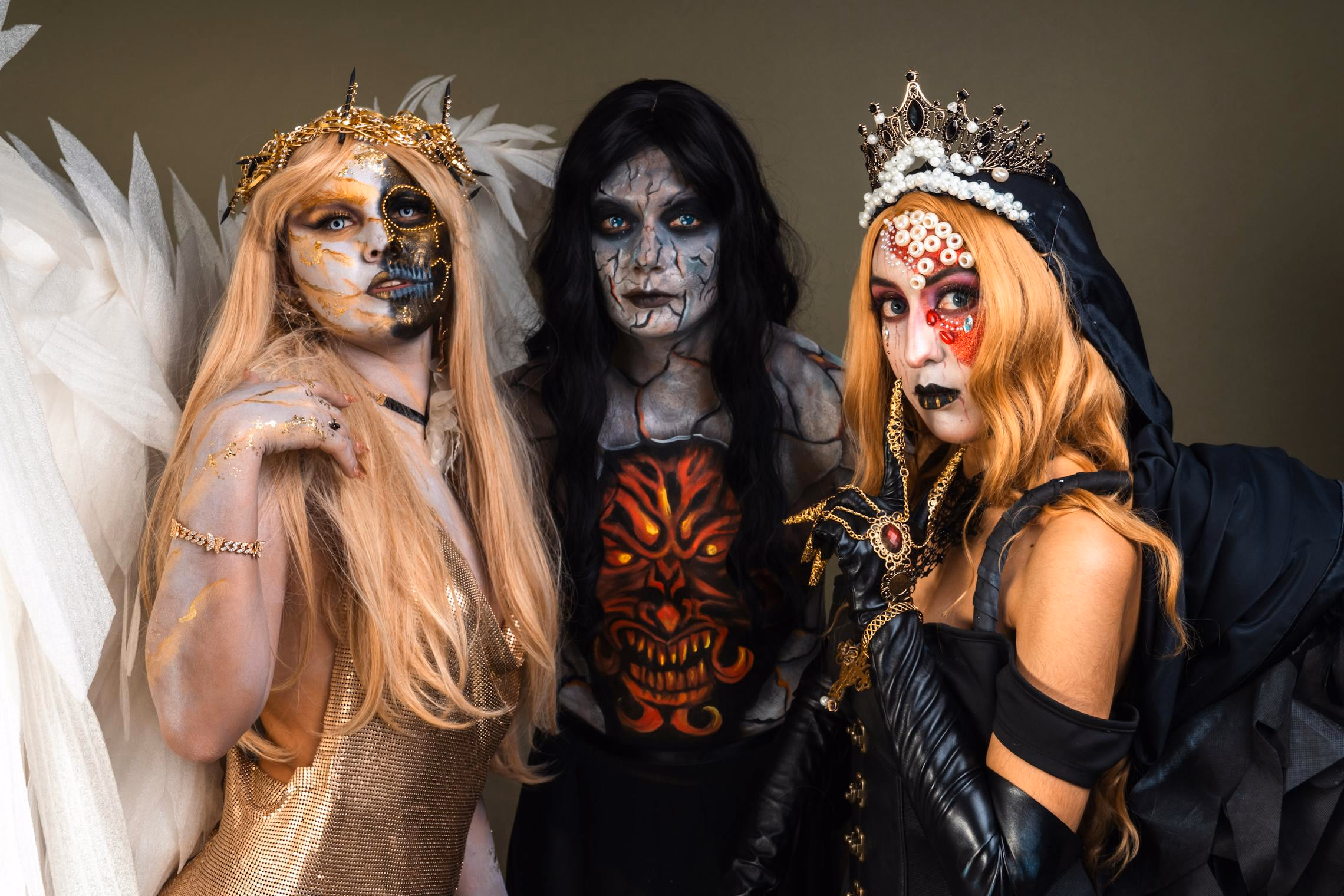 Adults in elaborate Halloween costumes walking a makeshift runway at a house party