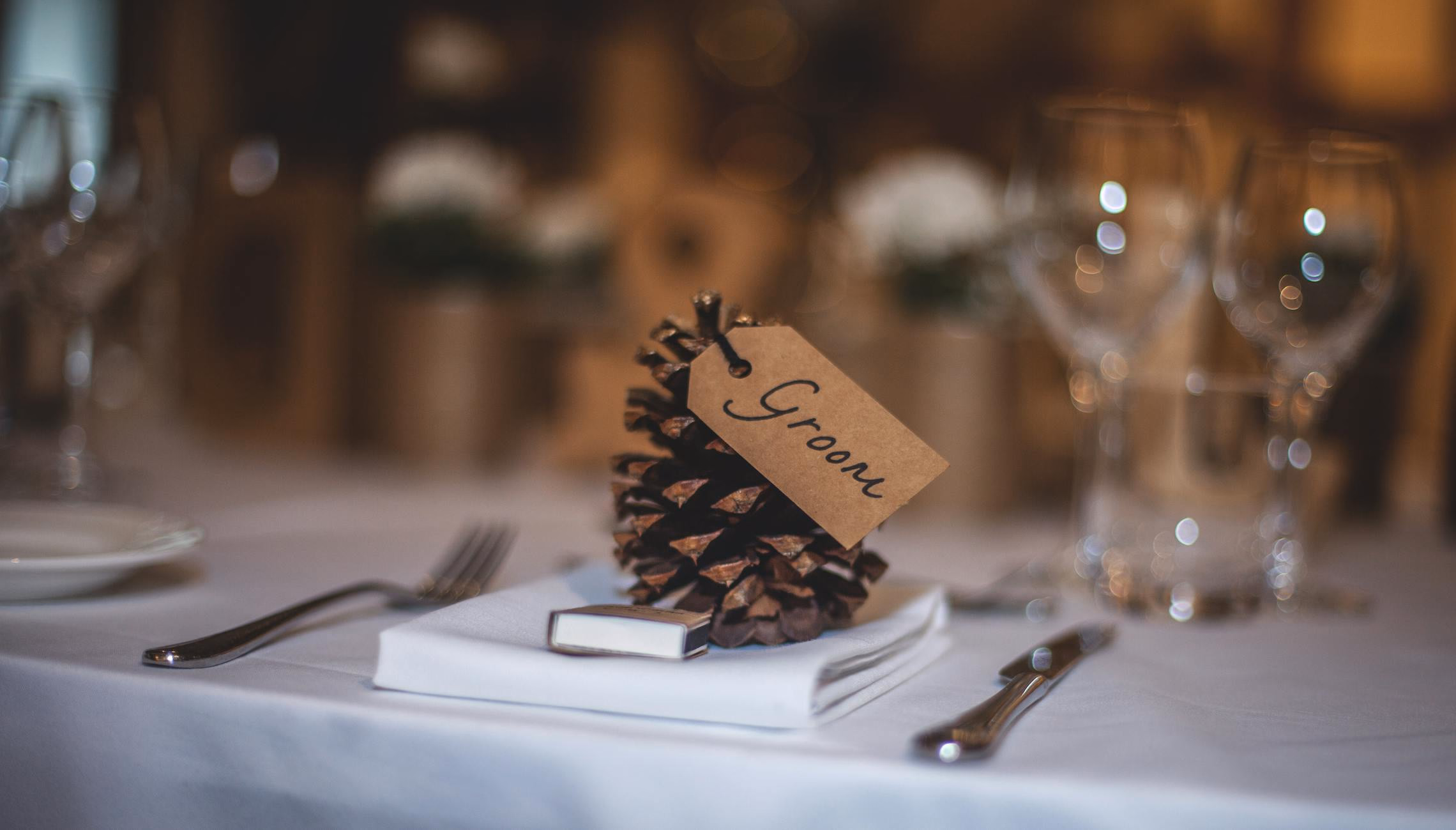 Row of gothic place cards with ornate borders standing on a candlelit dinner table