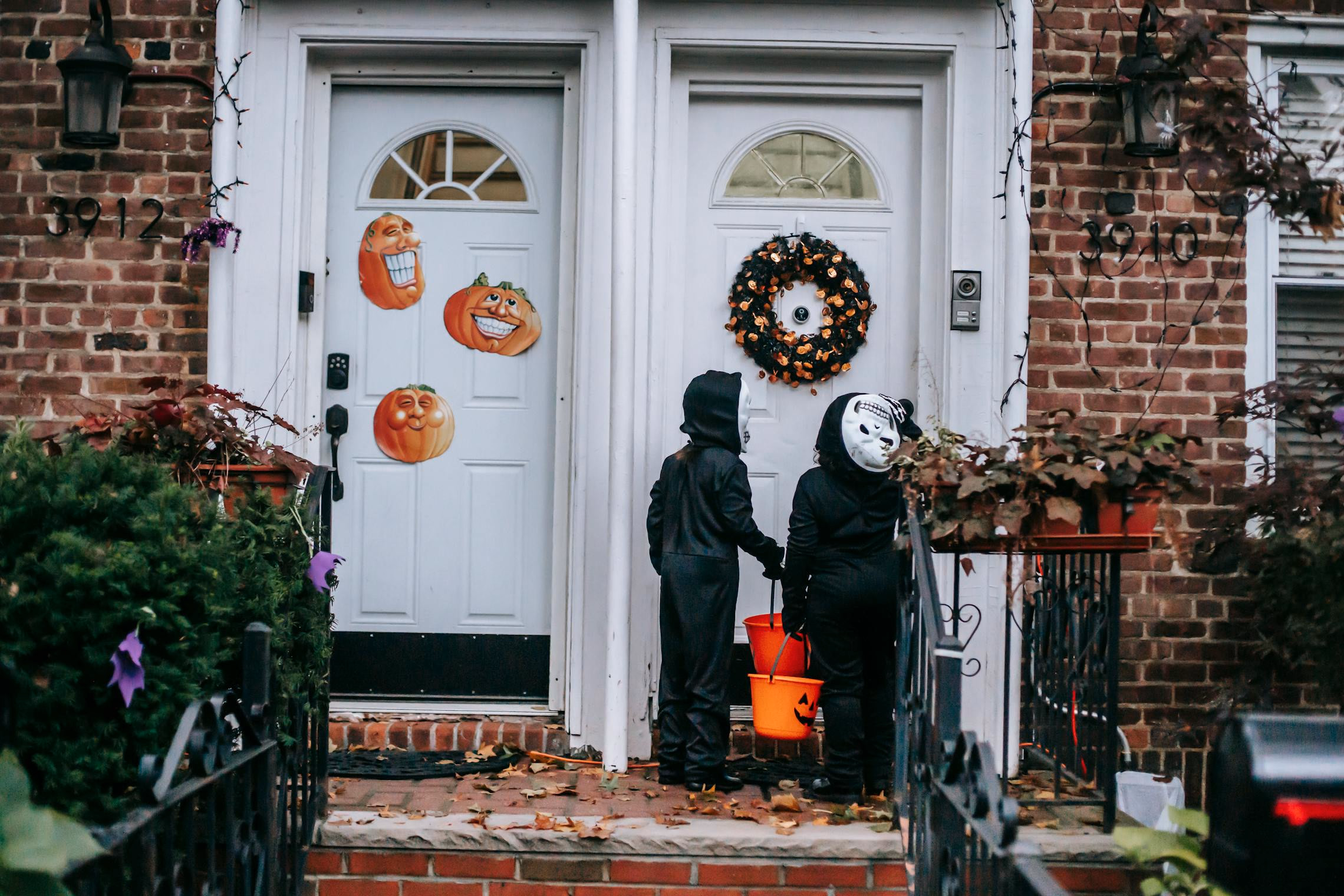 Children in Halloween costumes on a 1950s suburban street at dusk