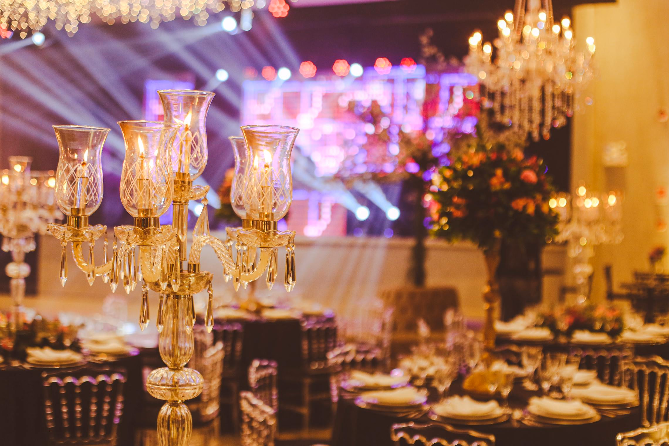 A gothic centerpiece with black candelabra, dark roses, and a decorative skull on a dark velvet table runner